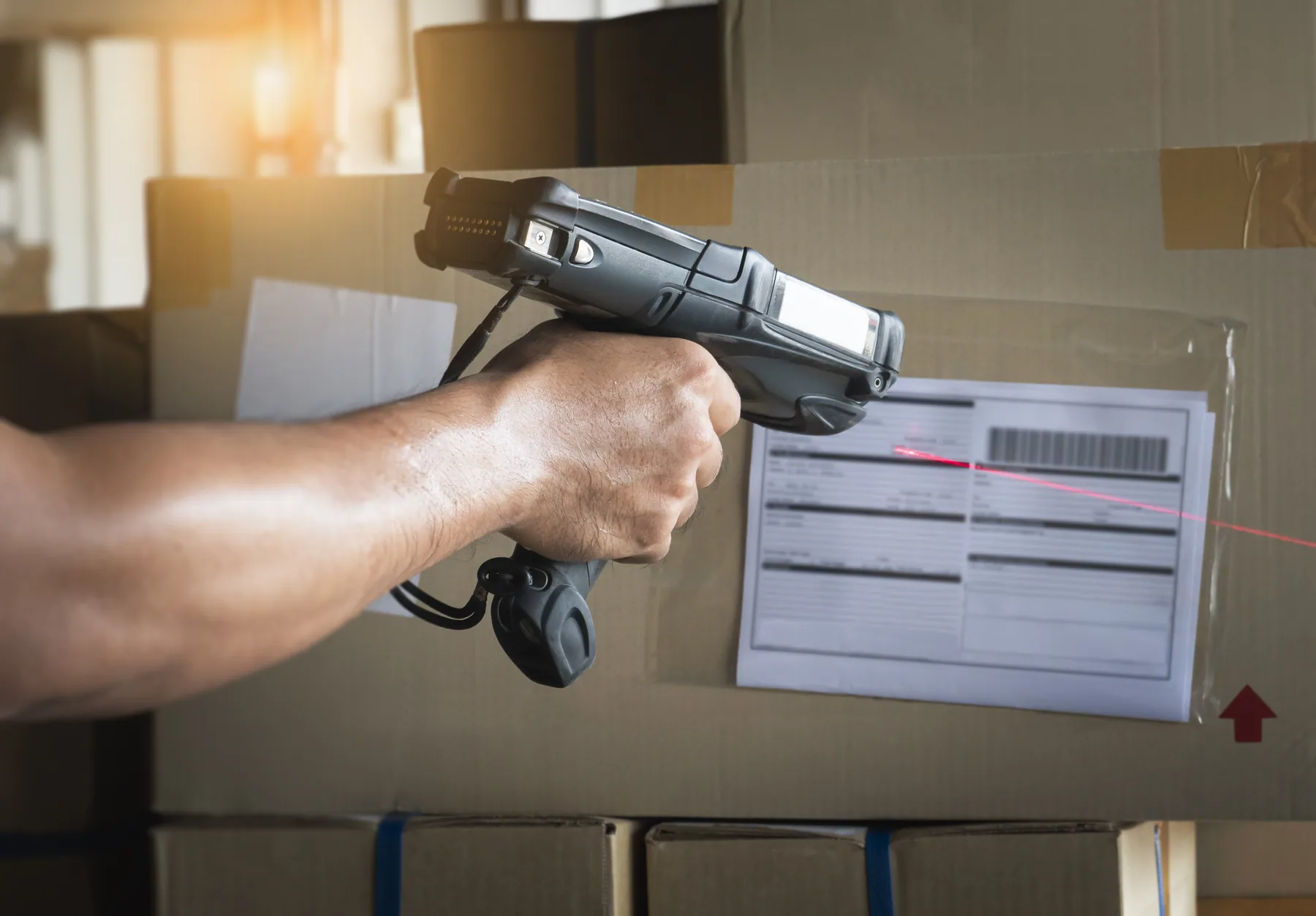 A handheld scanner reading the barcode on a shipping label