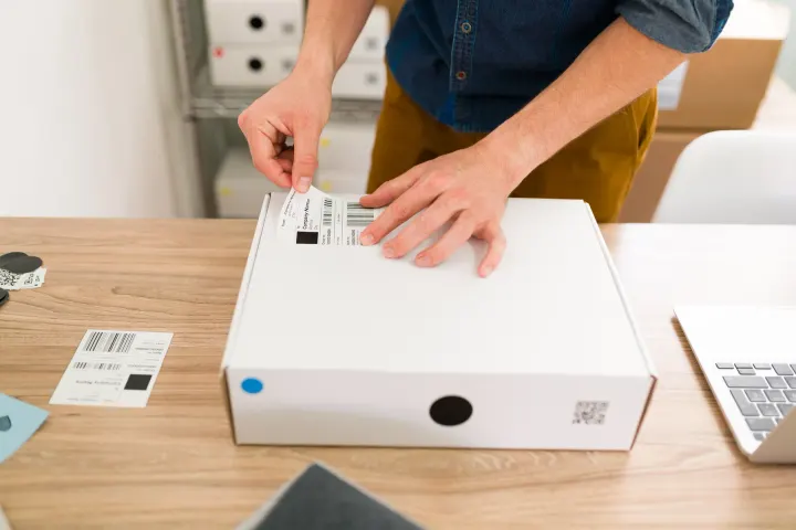 Applying a shipping label to a flat white box